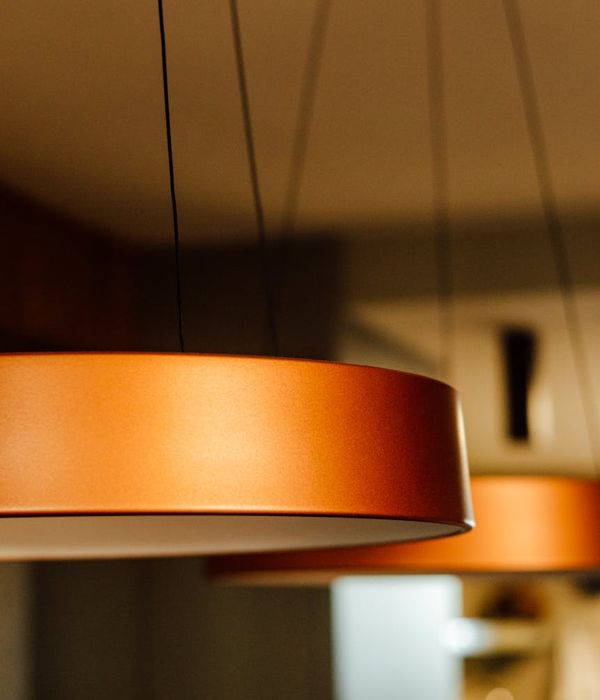 A person stretching in a minimalist room with soft, ambient lighting.