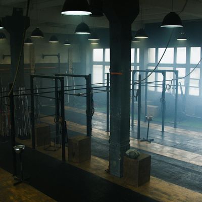 An empty yoga mat on a wooden floor in a bright room.